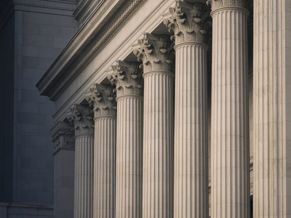 Detail of fluted stone columns and bronze lettering on a Chicago courthouse facade in soft side light